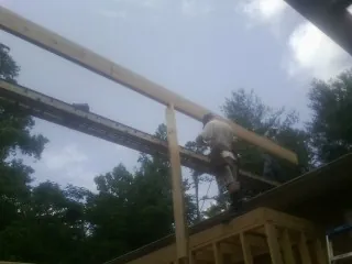 Carpenter setting a ridge beam over a new addition frame — Ice Dam Removal by Roofing Brothers in Casa Blanca