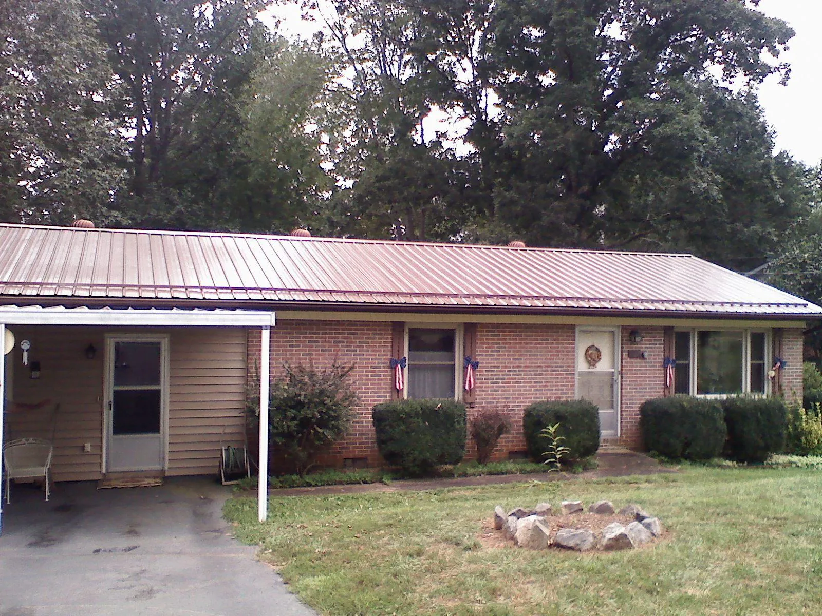 Bronze metal roof and carport on a brick ranch home — Roof Repair work by our crew in Casa Blanca